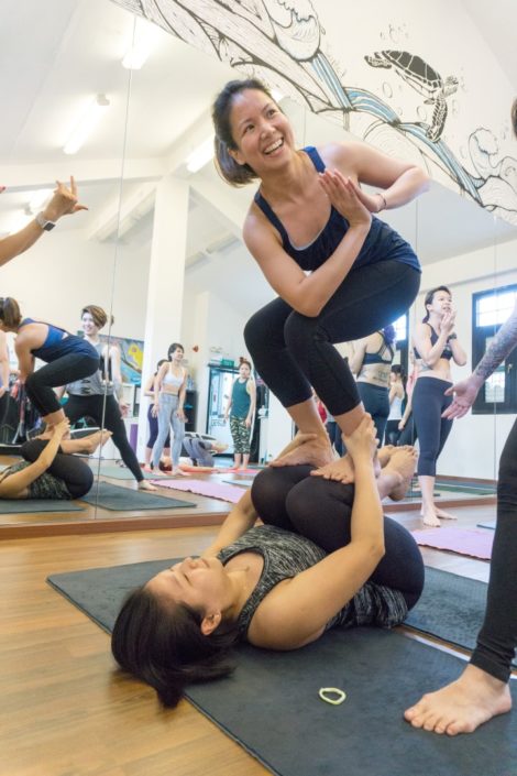 Lorraine looking happy in Twisted Chair Pose (Utkatasana) on shins.